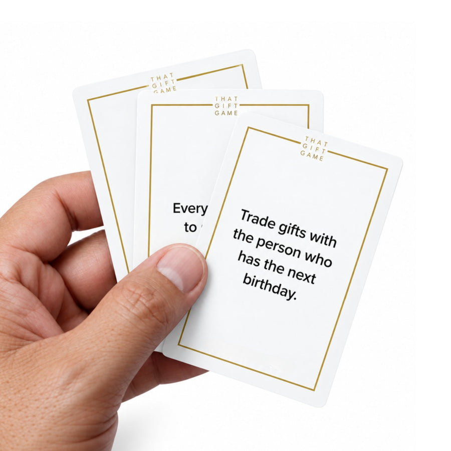 Three That Gift Game cards in hand, one reads Trade gifts with the person who has the next birthday