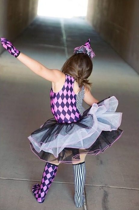 The clown costume from behind, dancing in a tunnel