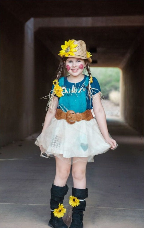 Girl in a DIY scarecrow costume with a straw hat and sunflower, a denim top and a white tulle skirt