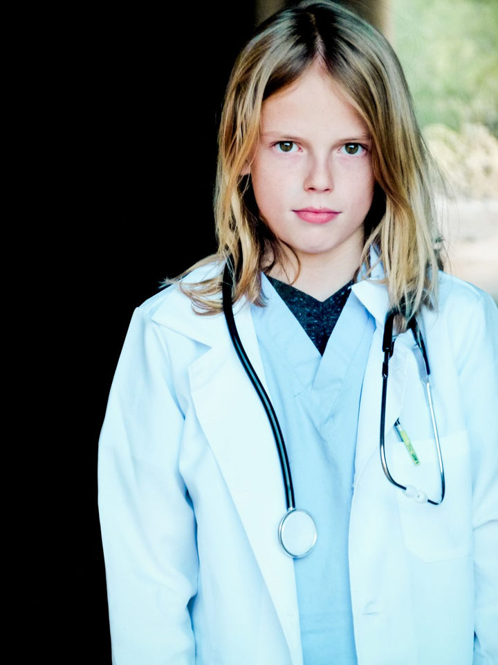 Girl in a doctor costume with scrubs, a white coat and a stethoscope