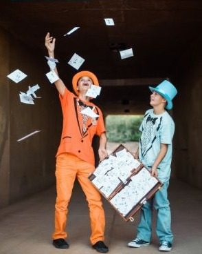 Harry and Lloyd costumes tossing IOU notes into the air