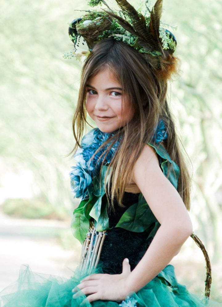 Girl in a Mother Nature costume with a crown of twigs and moss and a green tulle skirt