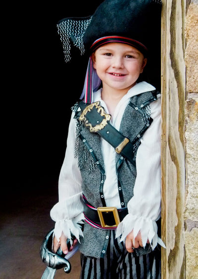 Little boy in a pirate costume with a black hat, vest and white shirt