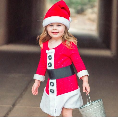 Toddler Santa carrying a metal bucket in a tunnel